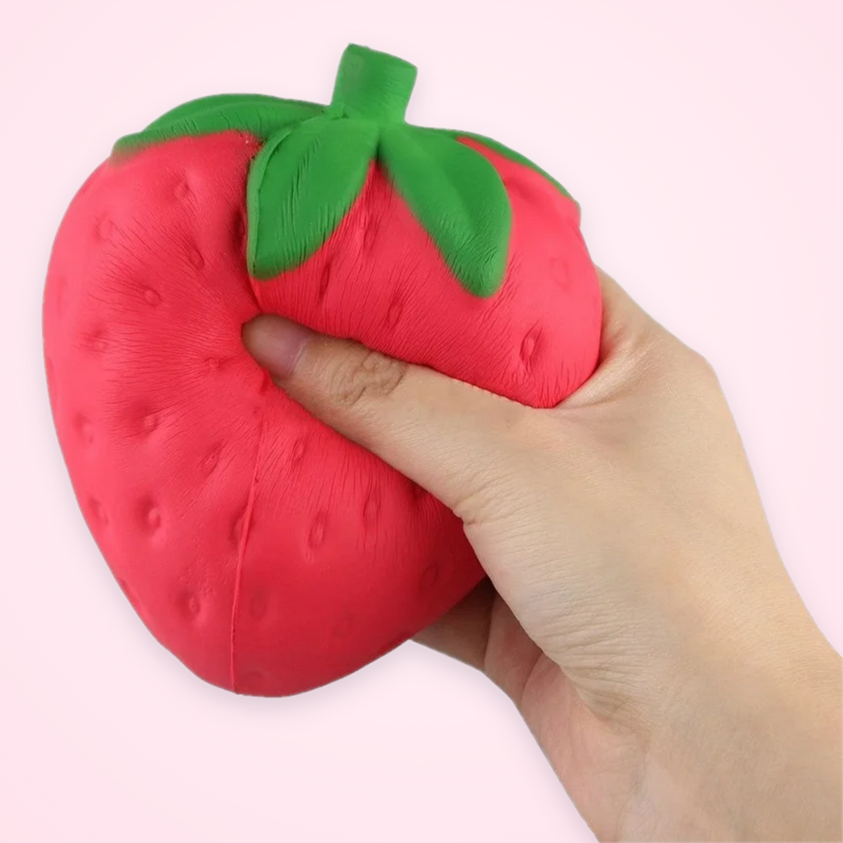 Jumbo Strawberry Squishy being squeezed in one hand